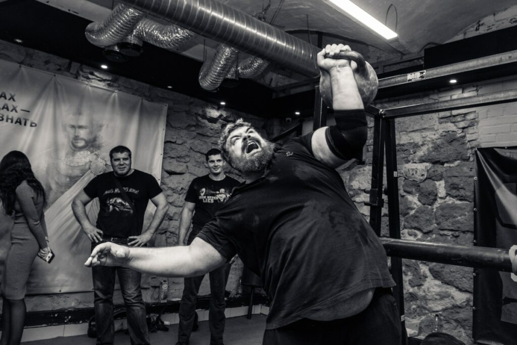 Strong man soulevant un haltère dans une salle de gym