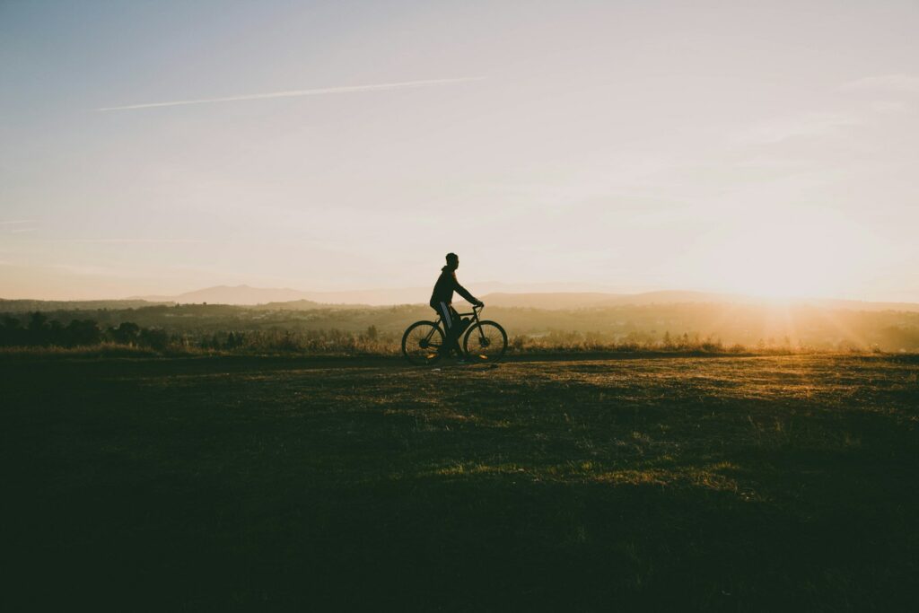 Une personne faisant du vélo dans la nature au coucher de soleil